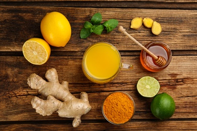 Photo of Flat lay composition with immunity boosting drink and ingredients on wooden table
