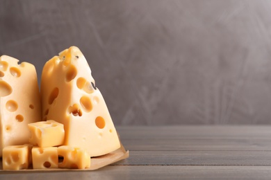 Photo of Tasty fresh cheese on wooden table, closeup. Space for text