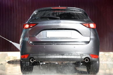 Photo of Cleaning automobile with high pressure water jet at car wash