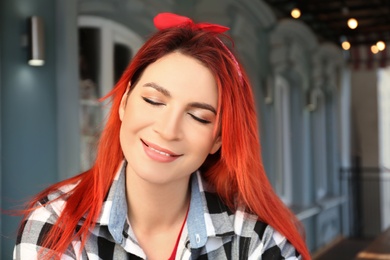 Photo of Young woman with bright dyed long hair outdoors
