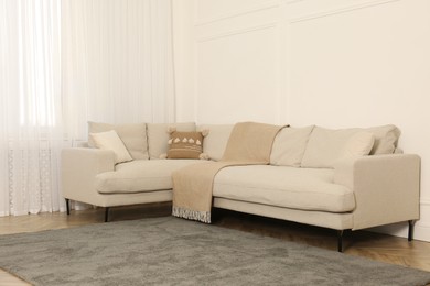 Photo of Comfortable sofa near white wall in living room