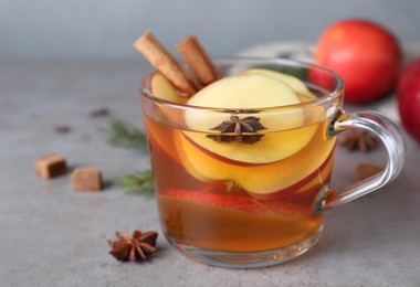Photo of Aromatic hot mulled cider on grey table