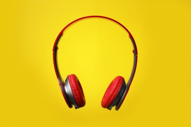 Photo of Stylish modern headphones with earmuffs on color background