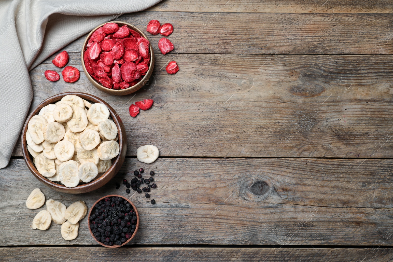 Bowls and dried fruits on wooden table, flat lay. Space for text Photo of Bowls and dried fruits on wooden table, flat lay. Space for text