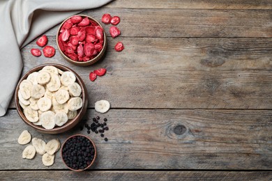 Photo of Bowls and dried fruits on wooden table, flat lay. Space for text