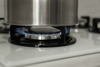 Photo of Steel kettle on modern gas stove, closeup
