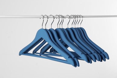 Photo of Metal rack with clothes hangers on white background