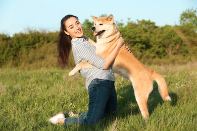 Photo of Young woman with adorable Akita Inu dog in park