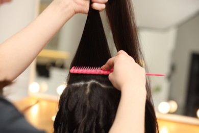 Photo of Hair styling. Professional hairdresser working with client in salon, closeup