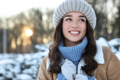 Photo of Portrait of smiling woman in snowy park. Space for text