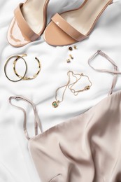 Photo of Flat lay composition with elegant bijouterie on white cloth