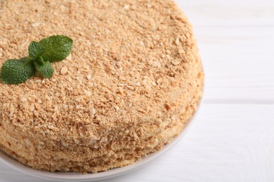 Photo of Delicious Napoleon cake on white wooden table, closeup