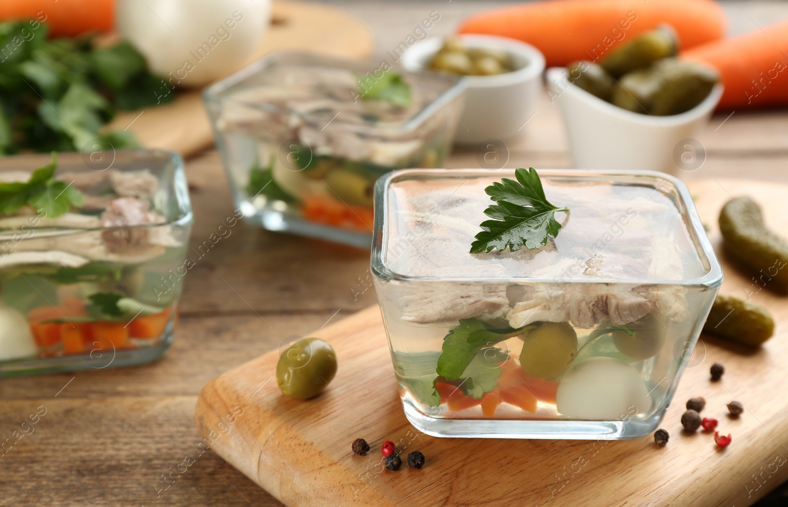 Photo of Delicious aspic with meat in bowl on wooden table. Space for text