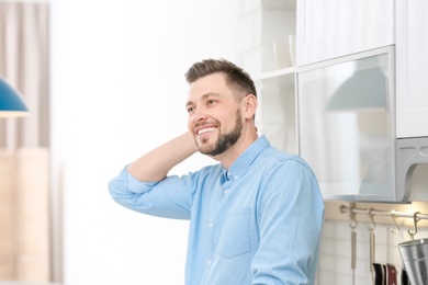 Photo of Portrait of handsome young man in kitchen