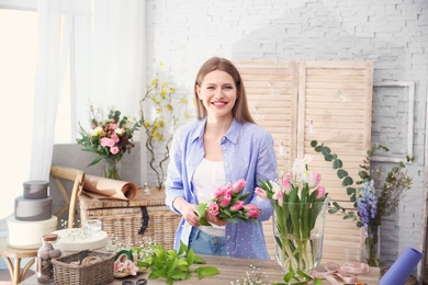 Photo of Female decorator creating beautiful bouquet at table