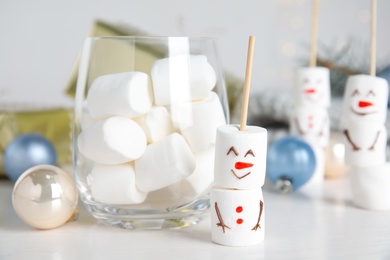 Photo of Funny snowman made of marshmallows on white table