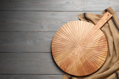 Photo of Cutting board with kitchen towel on grey wooden table, flat lay. Space for text
