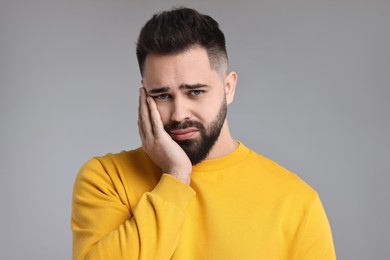 Photo of Portrait of sad man on light grey background