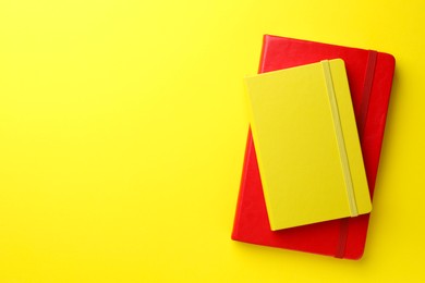 Photo of Different notebooks on yellow background, top view. Space for text