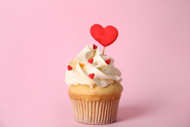 Photo of Tasty cupcake for Valentine's Day on pink background