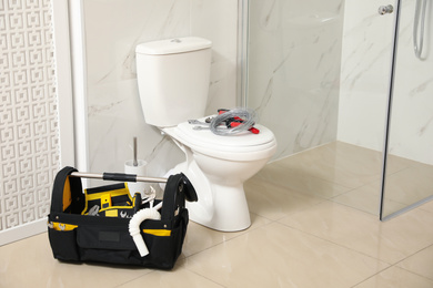 Photo of Plumber's tools near toilet bowl in bathroom