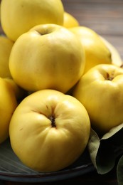 Photo of Fresh ripe organic quinces on plate, closeup