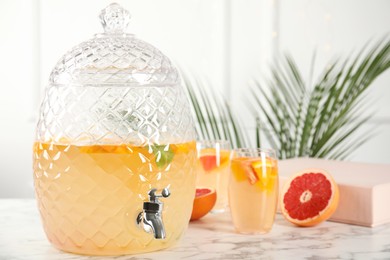 Photo of Beverage dispenser with delicious refreshing drink on white marble table. Space for text