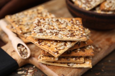Photo of Cereal crackers with flax, sunflower and sesame seeds on table, closeup
