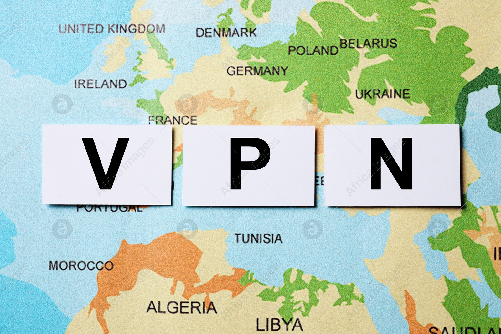 Photo of Paper notes with acronym VPN (Virtual Private Network) on world map, flat lay