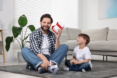 Photo of Happy Father's Day. Father guessing what inside gift box which giving him his son