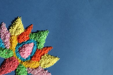 Photo of Diwali celebration. Colorful rangoli on blue background, top view. Space for text