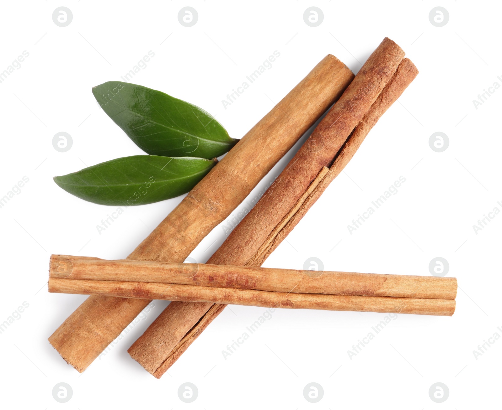 Photo of Cinnamon sticks and green leaves isolated on white, top view