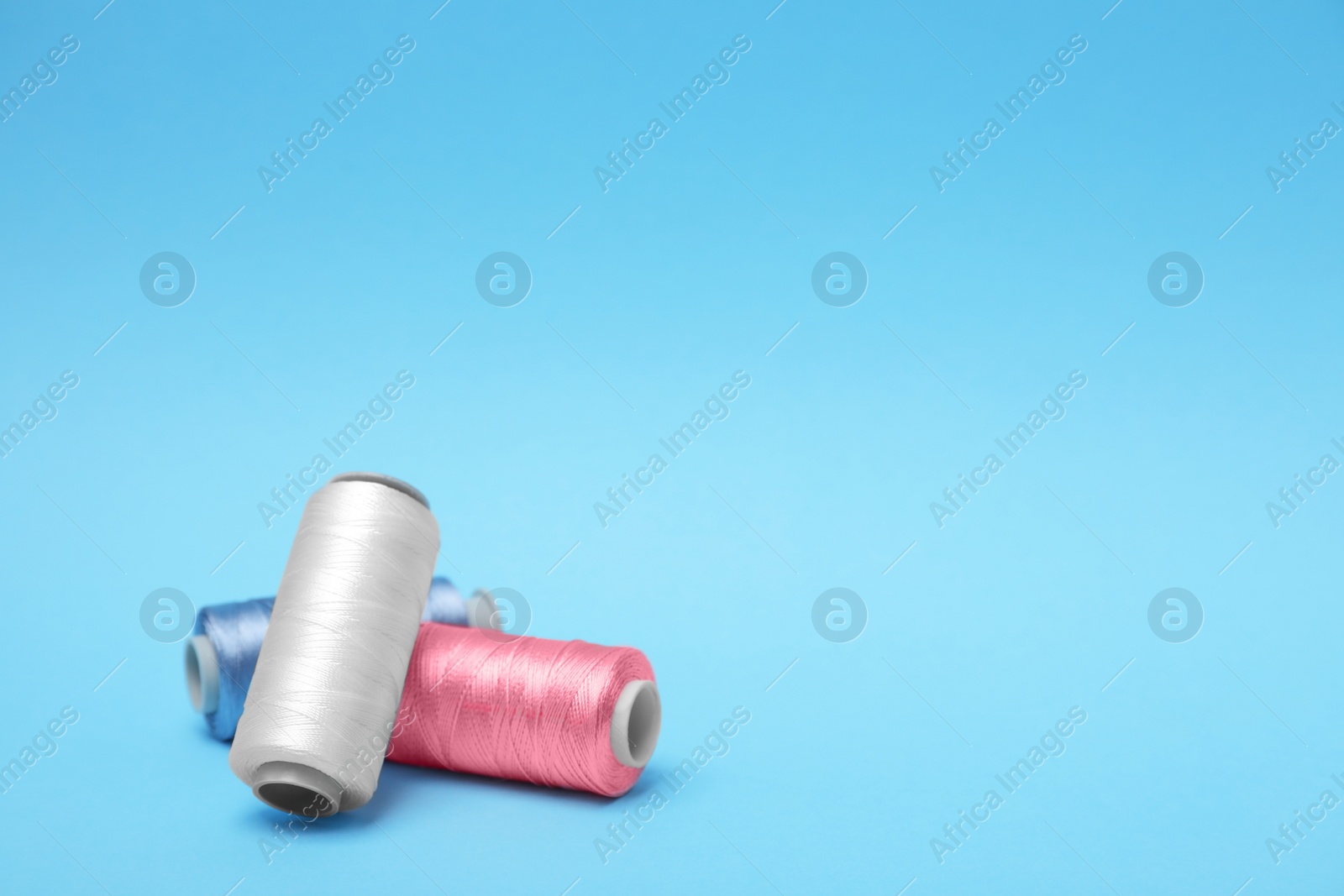 Photo of Different sewing threads on color background