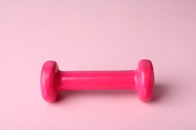 Photo of One color dumbbell on light pink background