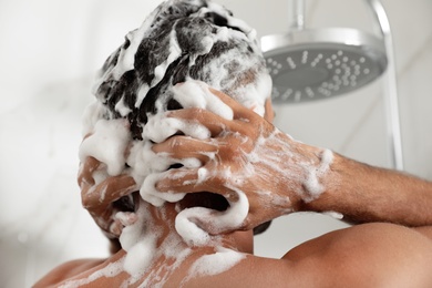 Photo of Man washing hair in shower at home, closeup