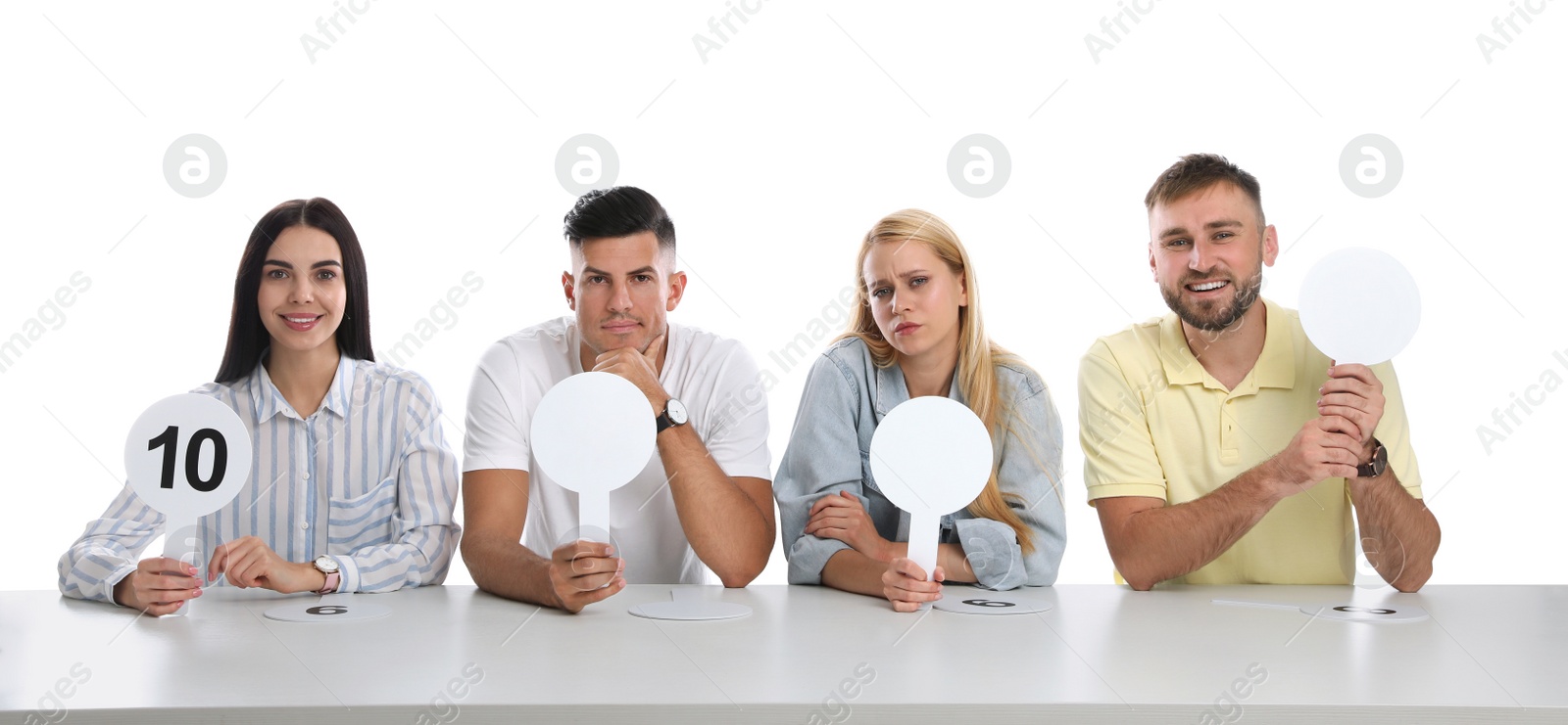 Photo of Panel of judges with different emotions holding blank signs at table on white background. Space for text