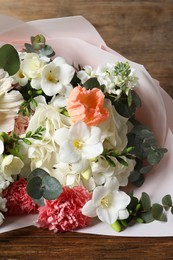 Photo of Bouquet of beautiful flowers on wooden table, closeup