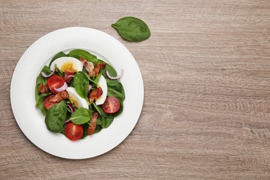 Photo of Delicious salad with boiled egg, bacon and vegetables on wooden table, flat lay. Space for text