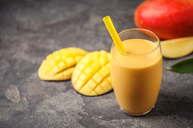 Fresh delicious mango drink on grey table. Space for text