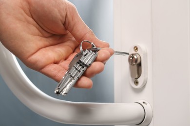 Photo of Man unlocking door with key, closeup view