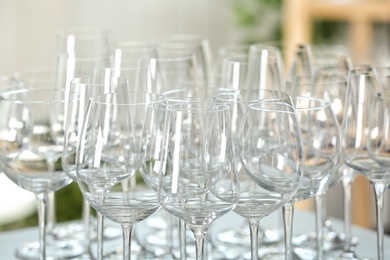 Photo of Empty glasses on table against blurred background, closeup