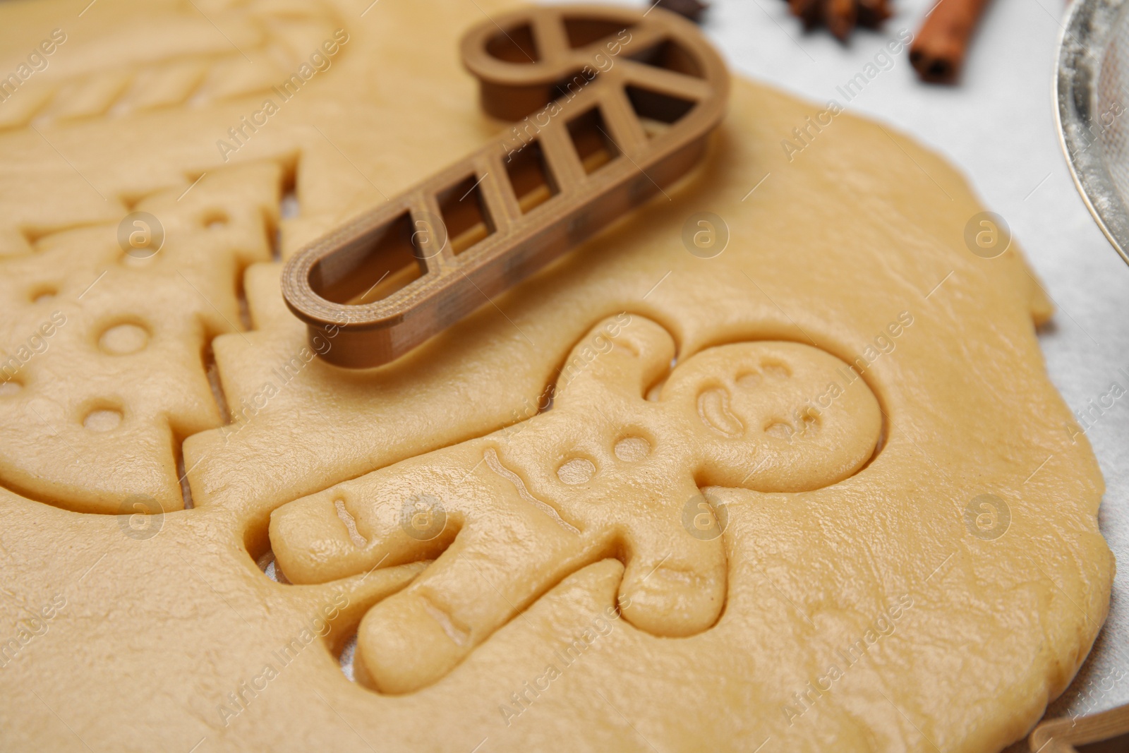 Photo of Christmas treat. Cookie cutter and dough on table, closeup