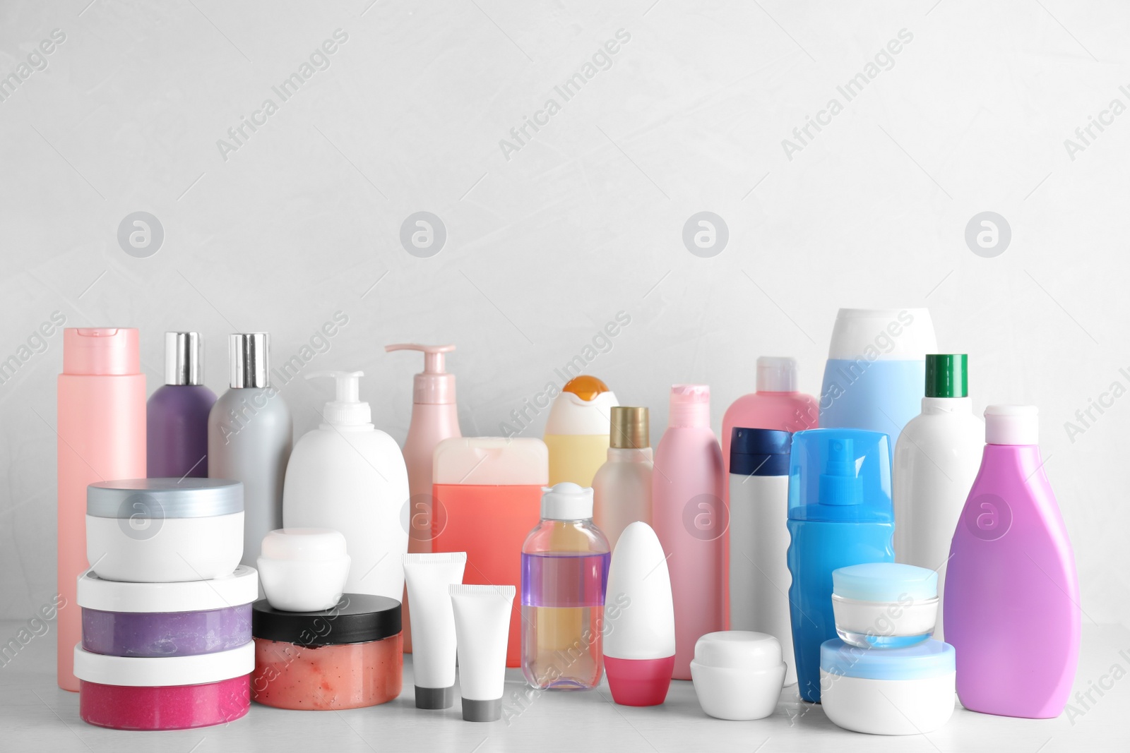 Photo of Different body care products on table against light background