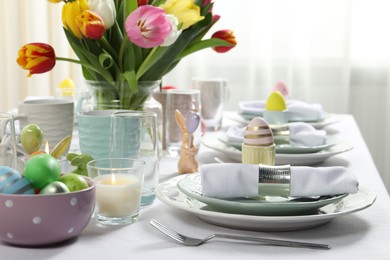 Photo of Easter celebration. Festive table setting with beautiful flowers and painted eggs