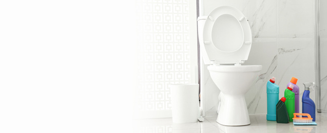 Image of Toilet bowl and cleaning supplies in modern bathroom, space for text. Banner design