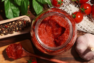 Photo of Jar of tasty tomato paste and ingredients on table, flat lay