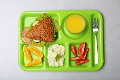 Photo of Serving tray with healthy food on light background, top view. School lunch