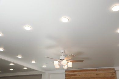 Photo of Modern ceiling fan with lamps indoors, below view