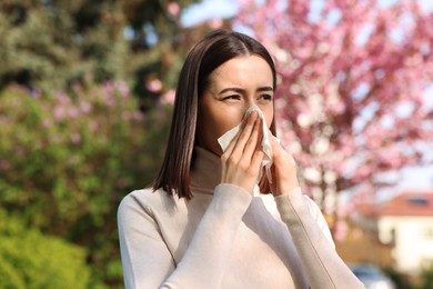 Photo of Woman with napkin suffering from seasonal allergy on spring day