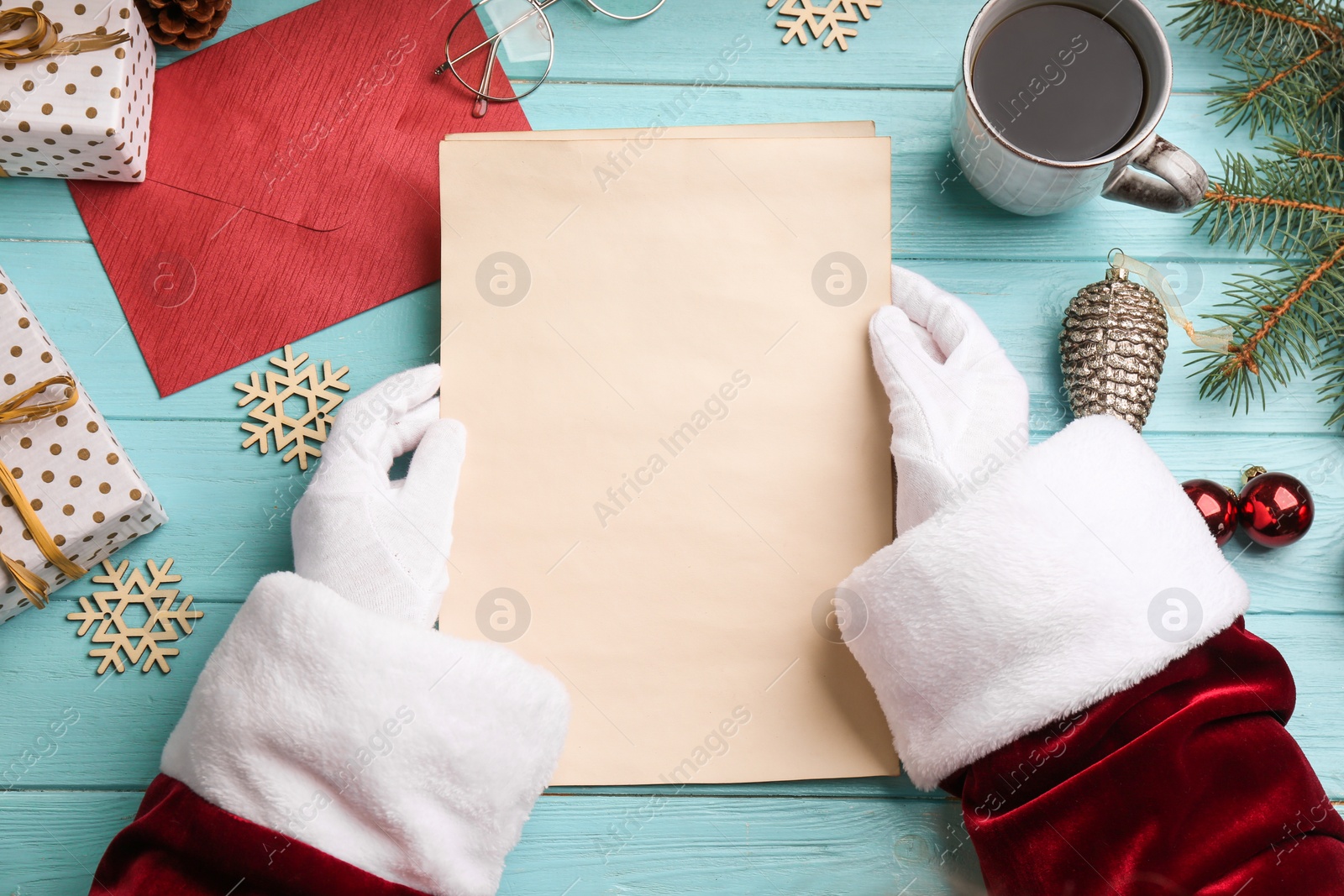 Photo of Santa holding letter at turquoise wooden table, top view